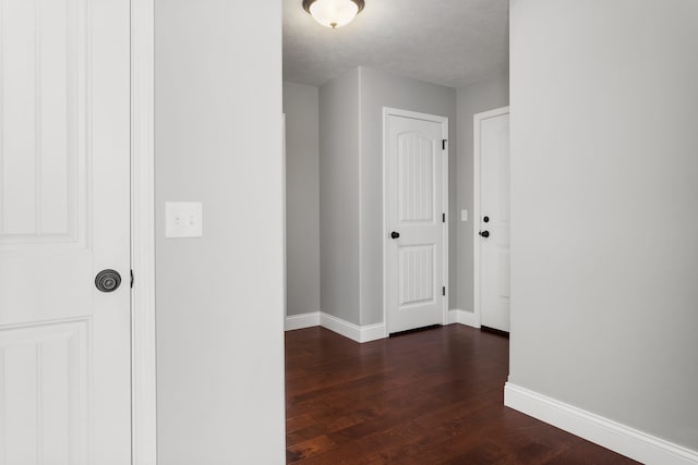 hall featuring dark hardwood / wood-style floors and a textured ceiling