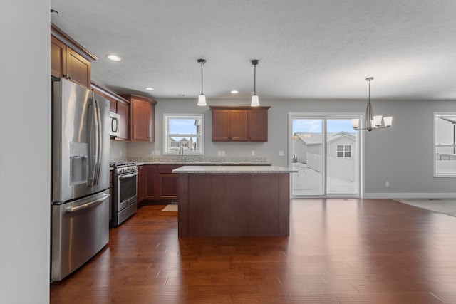 kitchen featuring a center island, stainless steel appliances, decorative light fixtures, and an inviting chandelier