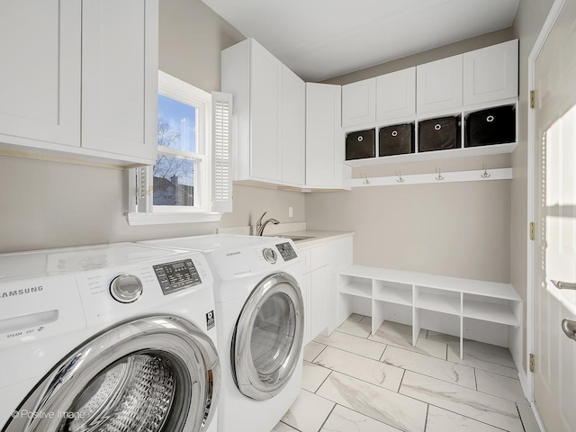 washroom with washer and dryer, cabinets, and sink