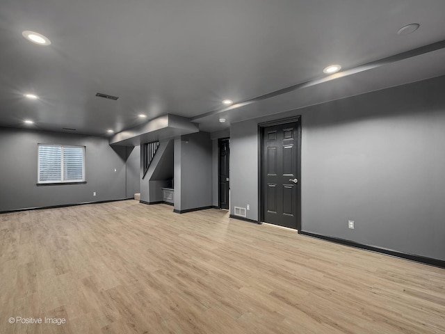 basement with light hardwood / wood-style flooring