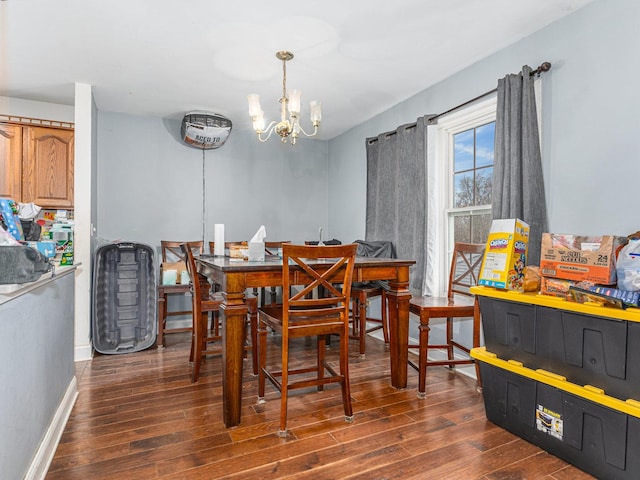 dining space featuring dark hardwood / wood-style floors and a chandelier