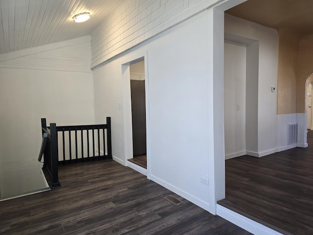 hall with dark wood-type flooring, wooden ceiling, and lofted ceiling