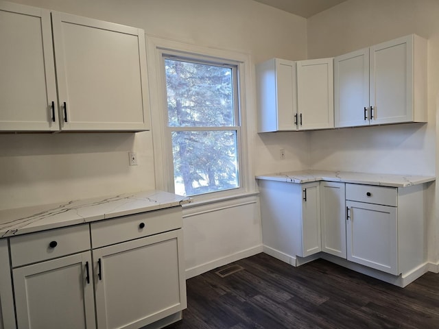 kitchen featuring white cabinetry, plenty of natural light, and light stone counters