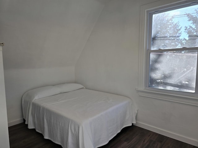 bedroom with dark hardwood / wood-style flooring and vaulted ceiling