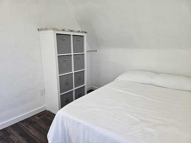 bedroom with dark hardwood / wood-style floors and lofted ceiling