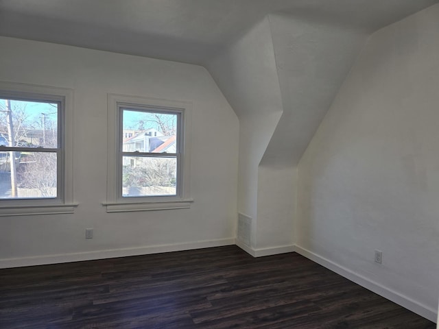 additional living space with vaulted ceiling and dark hardwood / wood-style floors