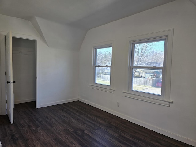 additional living space with dark hardwood / wood-style flooring and vaulted ceiling