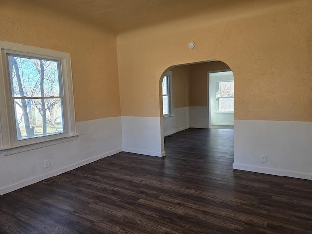 unfurnished room with dark wood-type flooring