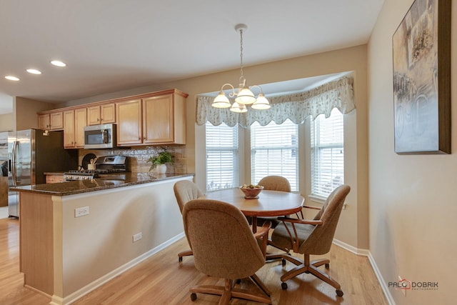 dining room with light wood-type flooring and a notable chandelier