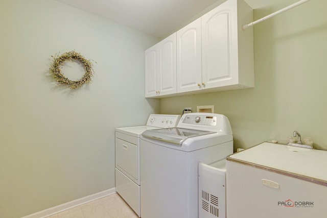 laundry room with washing machine and clothes dryer, sink, and cabinets