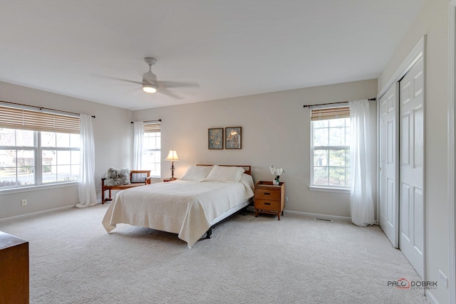 carpeted bedroom featuring multiple windows, a closet, and ceiling fan