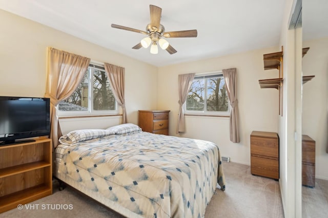 bedroom with ceiling fan and light colored carpet