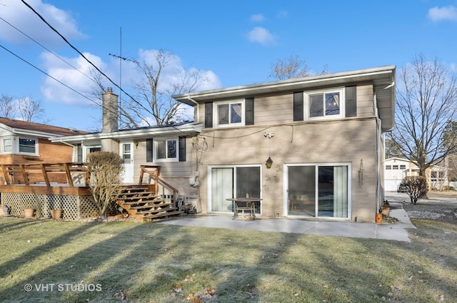 back of property with a wooden deck, a patio area, and a yard