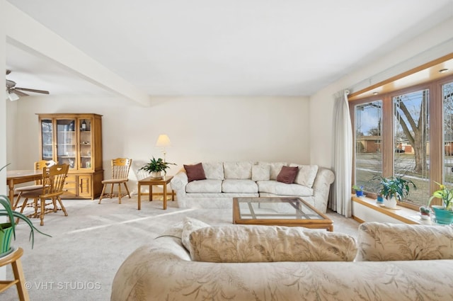 living room featuring light carpet, ceiling fan, and beamed ceiling