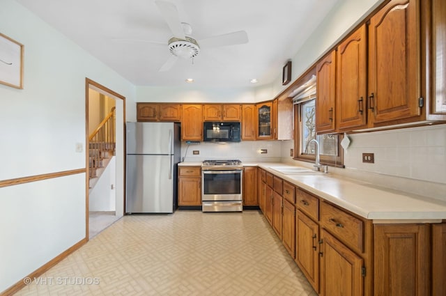 kitchen featuring appliances with stainless steel finishes, backsplash, ceiling fan, and sink