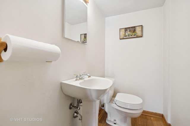 bathroom featuring hardwood / wood-style floors and toilet