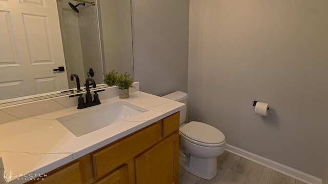 bathroom with vanity, wood-type flooring, and toilet