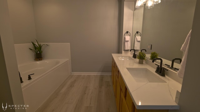 bathroom featuring a tub to relax in, vanity, and hardwood / wood-style flooring