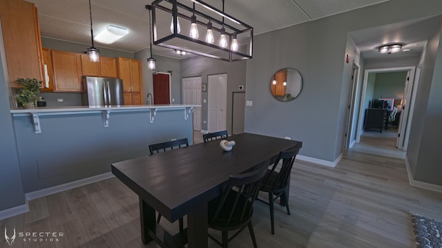 dining area featuring light hardwood / wood-style flooring and a textured ceiling