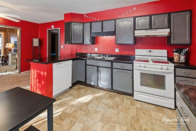 kitchen with kitchen peninsula, white appliances, and sink