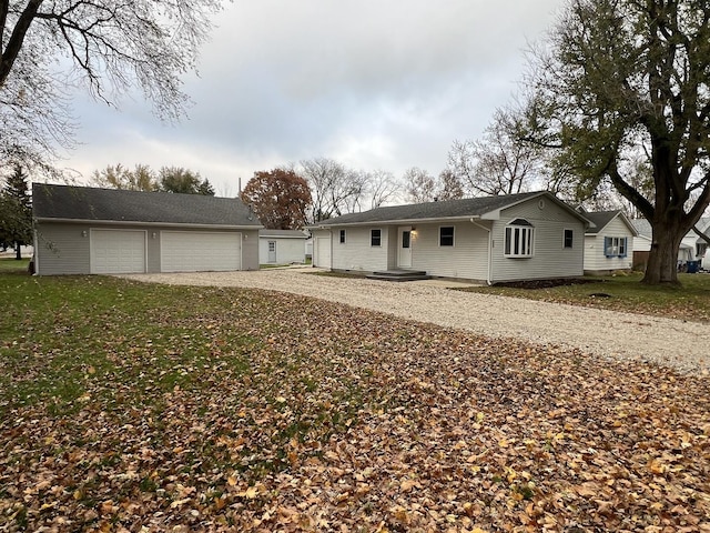 ranch-style home with a garage and a front lawn