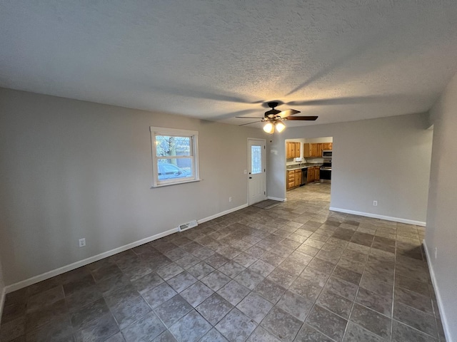 unfurnished room featuring ceiling fan and a textured ceiling