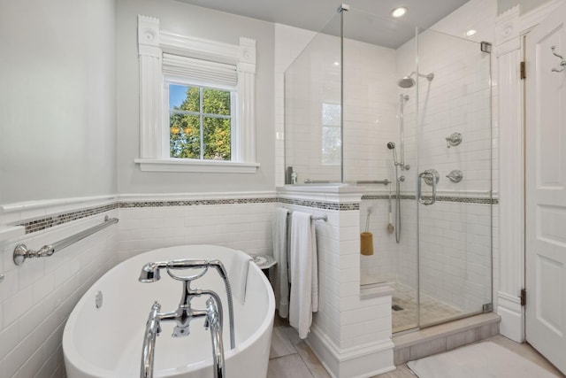 bathroom with tile walls and independent shower and bath