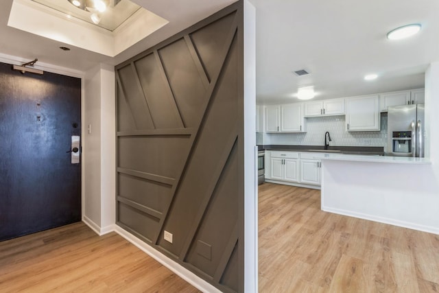 kitchen with white cabinetry, sink, light wood-type flooring, and appliances with stainless steel finishes