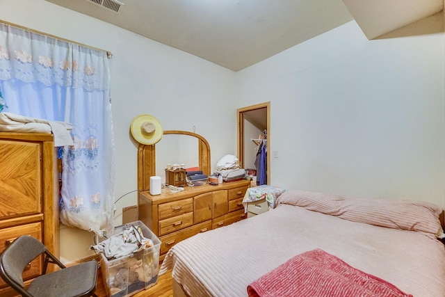 bedroom featuring hardwood / wood-style floors, a walk in closet, and a closet