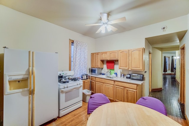 kitchen with light brown cabinetry, white appliances, ceiling fan, sink, and hardwood / wood-style floors