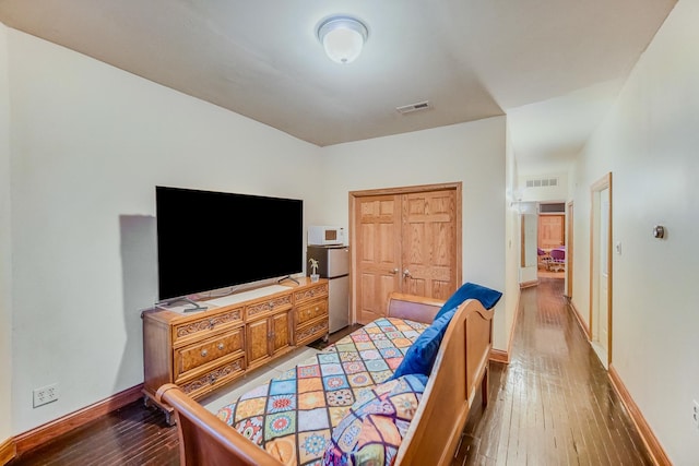 bedroom with hardwood / wood-style floors and a closet