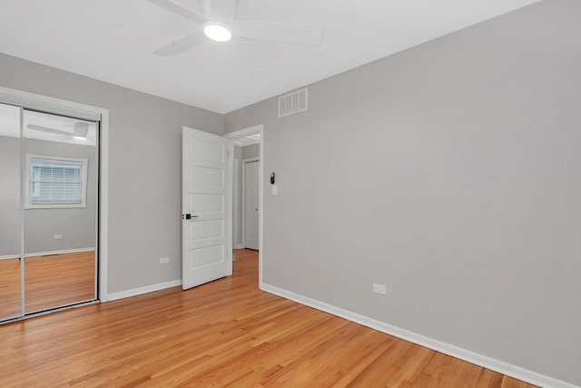 unfurnished bedroom featuring ceiling fan, light hardwood / wood-style floors, and a closet