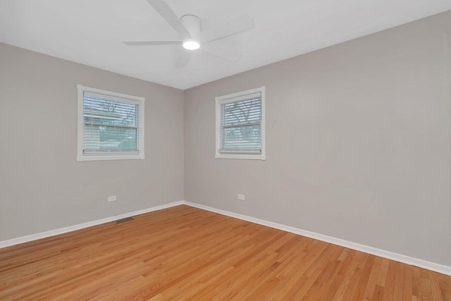 unfurnished room featuring ceiling fan, plenty of natural light, and light wood-type flooring