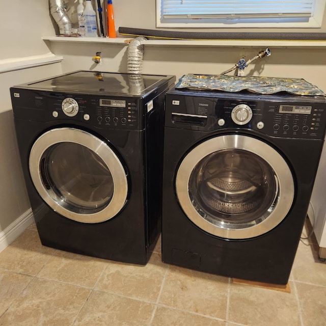 laundry room featuring washing machine and dryer and light tile patterned floors