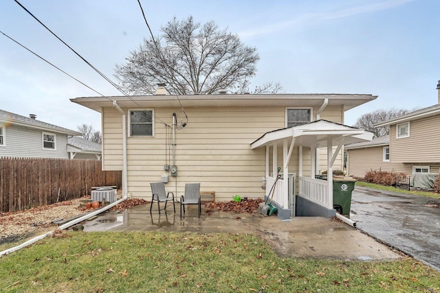 rear view of house featuring a yard, central AC, and a patio