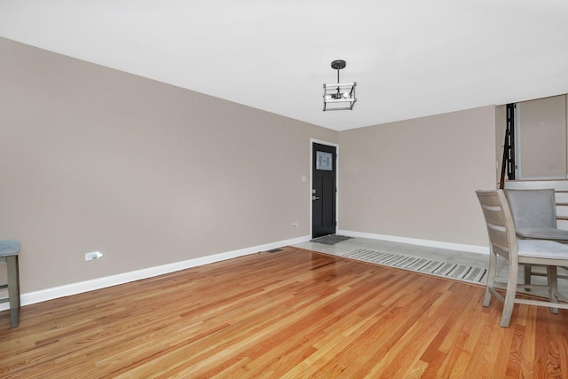 unfurnished dining area with a chandelier and light hardwood / wood-style floors