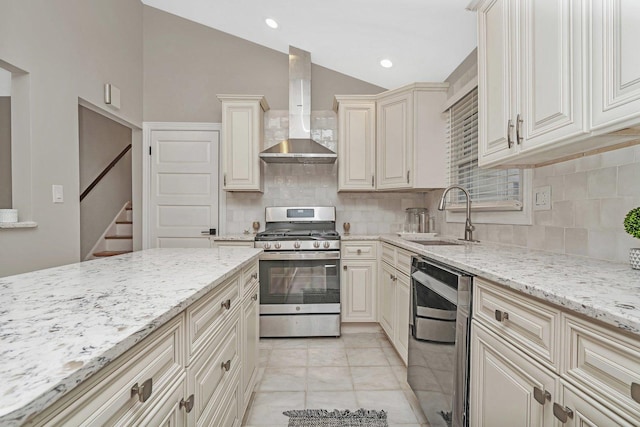 kitchen featuring lofted ceiling, wall chimney exhaust hood, sink, stainless steel gas stove, and light stone countertops