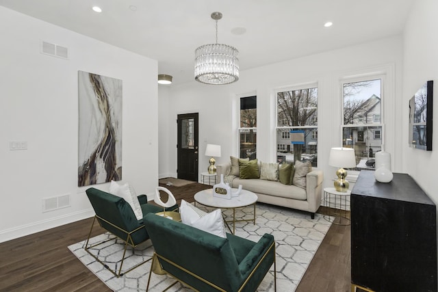 living room featuring dark wood-type flooring and a notable chandelier