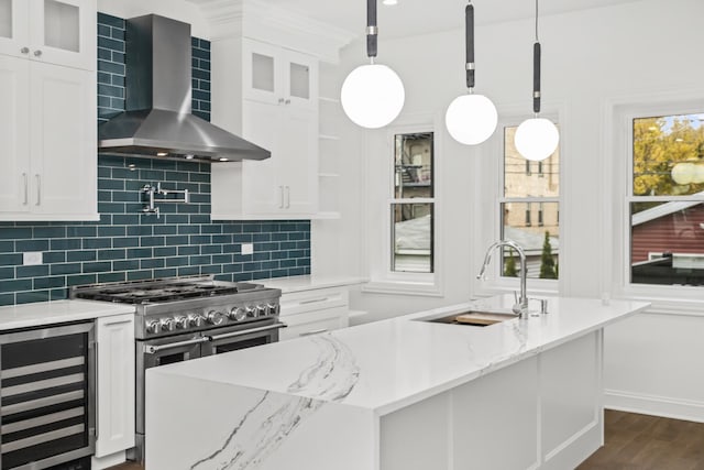 kitchen with wine cooler, stainless steel range, wall chimney range hood, and pendant lighting