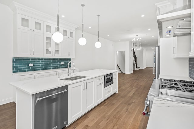 kitchen with sink, white cabinetry, stainless steel appliances, and a kitchen island with sink