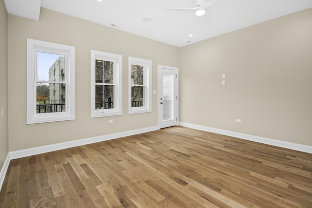 unfurnished room featuring ceiling fan, hardwood / wood-style floors, and a wealth of natural light