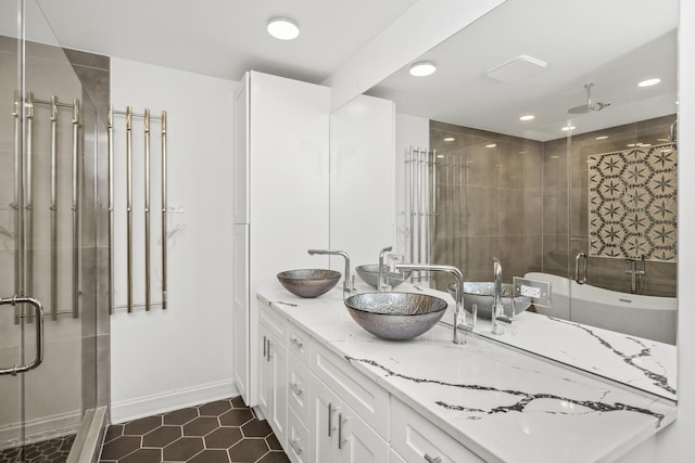 bathroom with a shower with shower door, vanity, and tile patterned flooring