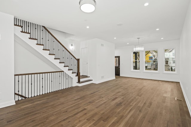 unfurnished living room featuring dark hardwood / wood-style flooring and a chandelier