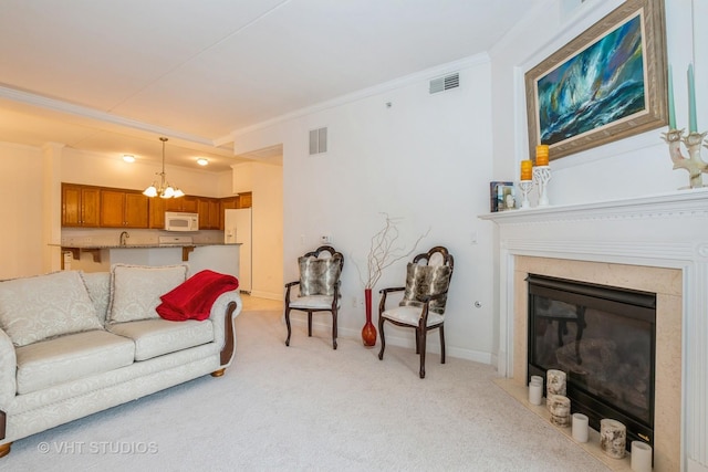 living room featuring ornamental molding, light colored carpet, and an inviting chandelier