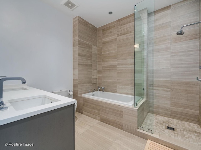 full bathroom featuring toilet, vanity, tile patterned floors, and shower with separate bathtub