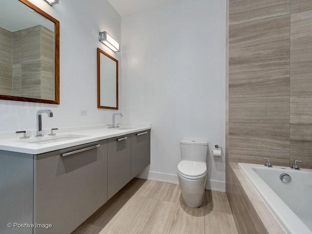 bathroom with tiled bath, toilet, and vanity