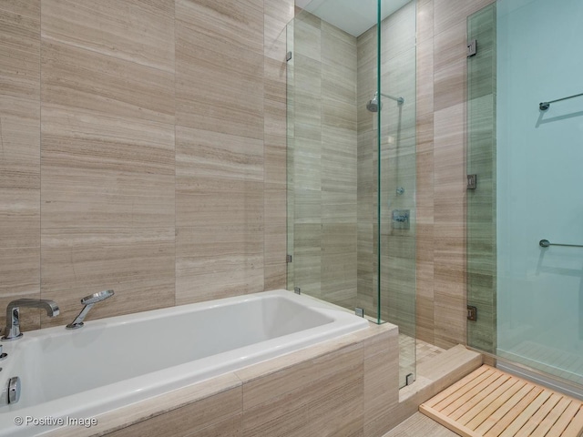 bathroom featuring separate shower and tub