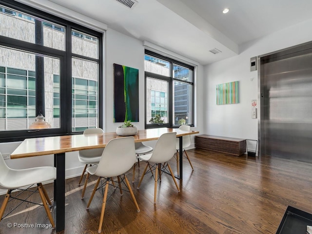 dining area featuring dark wood-type flooring and elevator