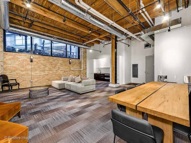 interior space with wood ceiling, brick wall, rail lighting, and carpet