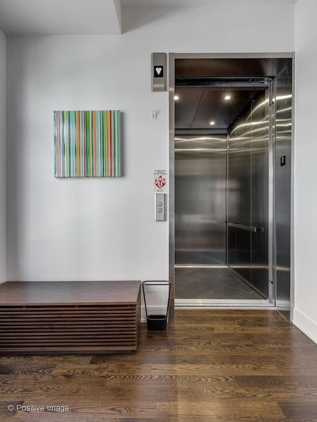 interior details with wood-type flooring and elevator